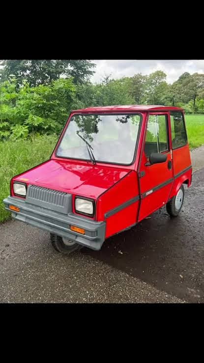 Unser echter roter Casalini Sulky, geparkt vor einem grünen Garten